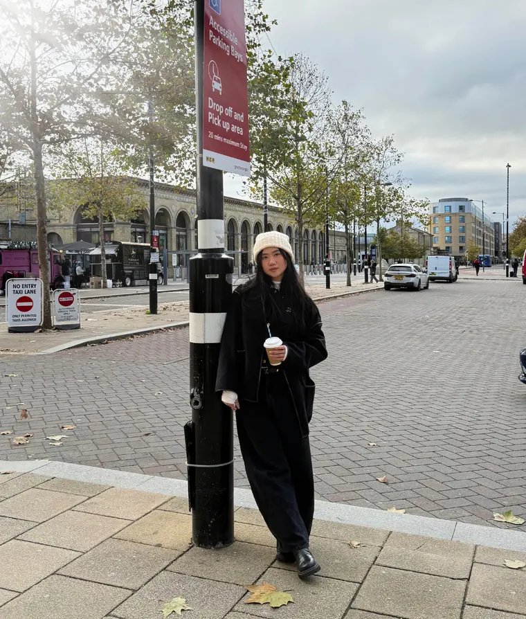 A Britannia Gateway student standing outside a UK railway station